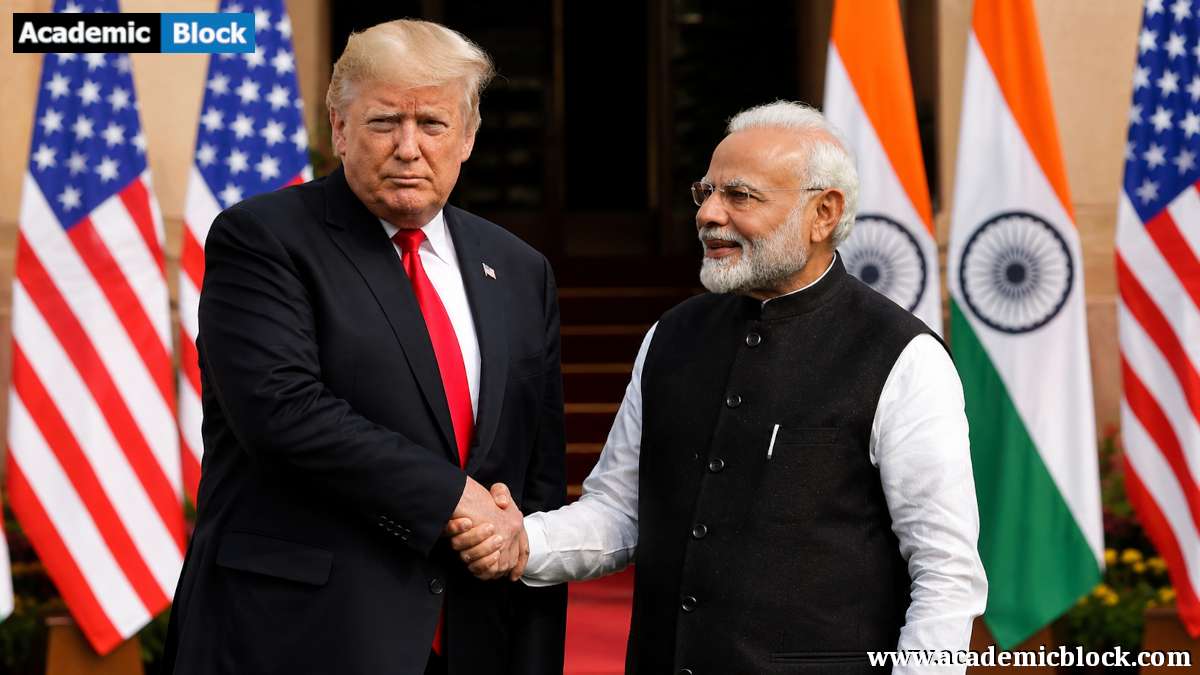 Donald Trump and Narendra Modi shake hands during a diplomatic meeting, with U.S. and Indian flags displayed in the background.