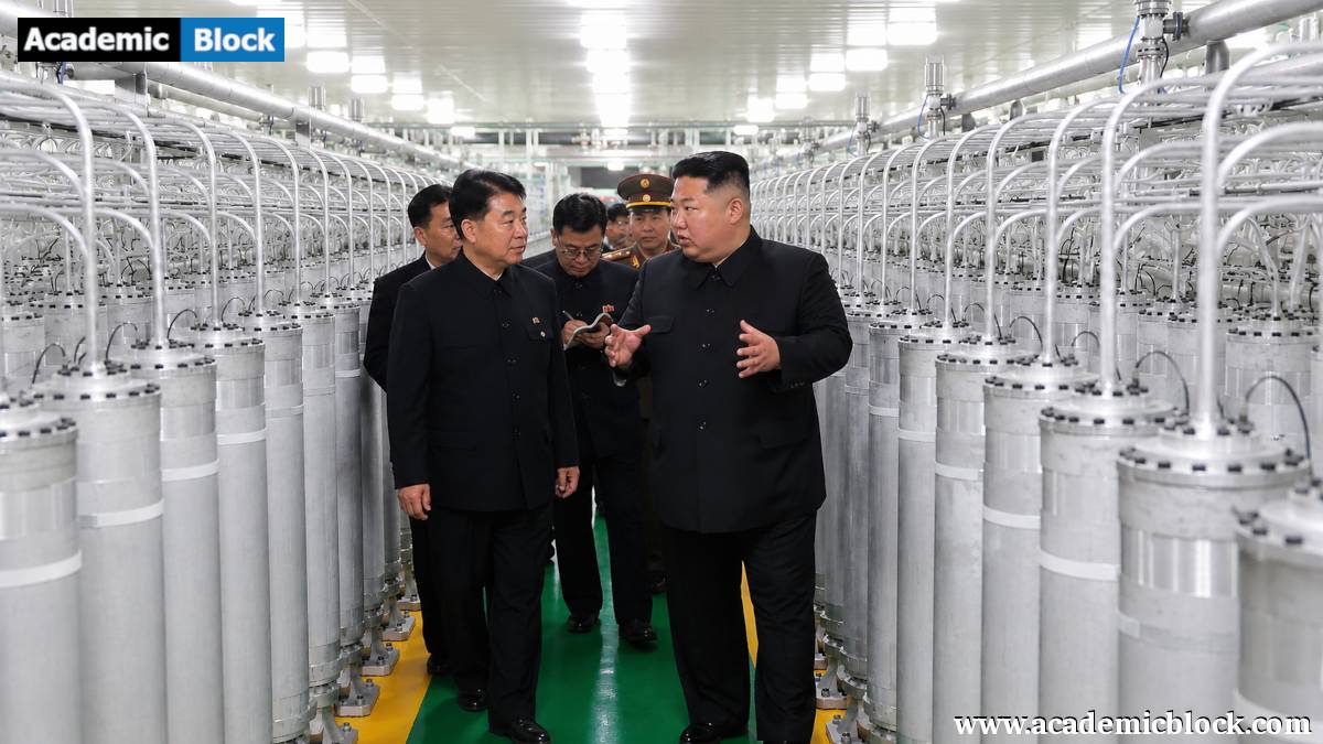 Kim Jong Un speaks with senior officials while walking through a uranium enrichment facility lined with rows of industrial centrifuges.