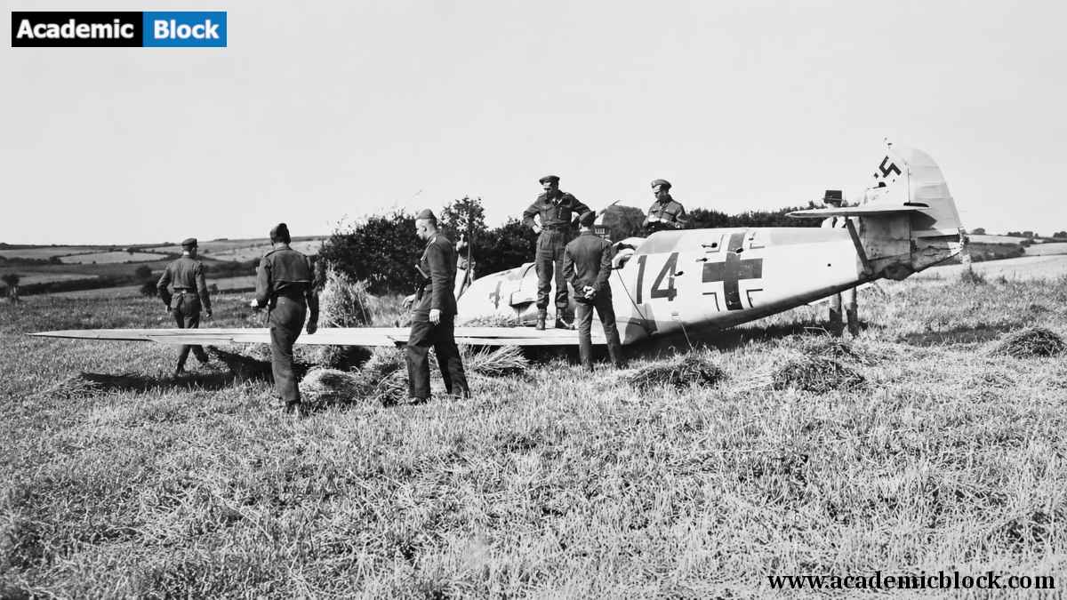 German soldiers inspect a damaged Luftwaffe aircraft in a rural field during the Battle of Britain, World War II.