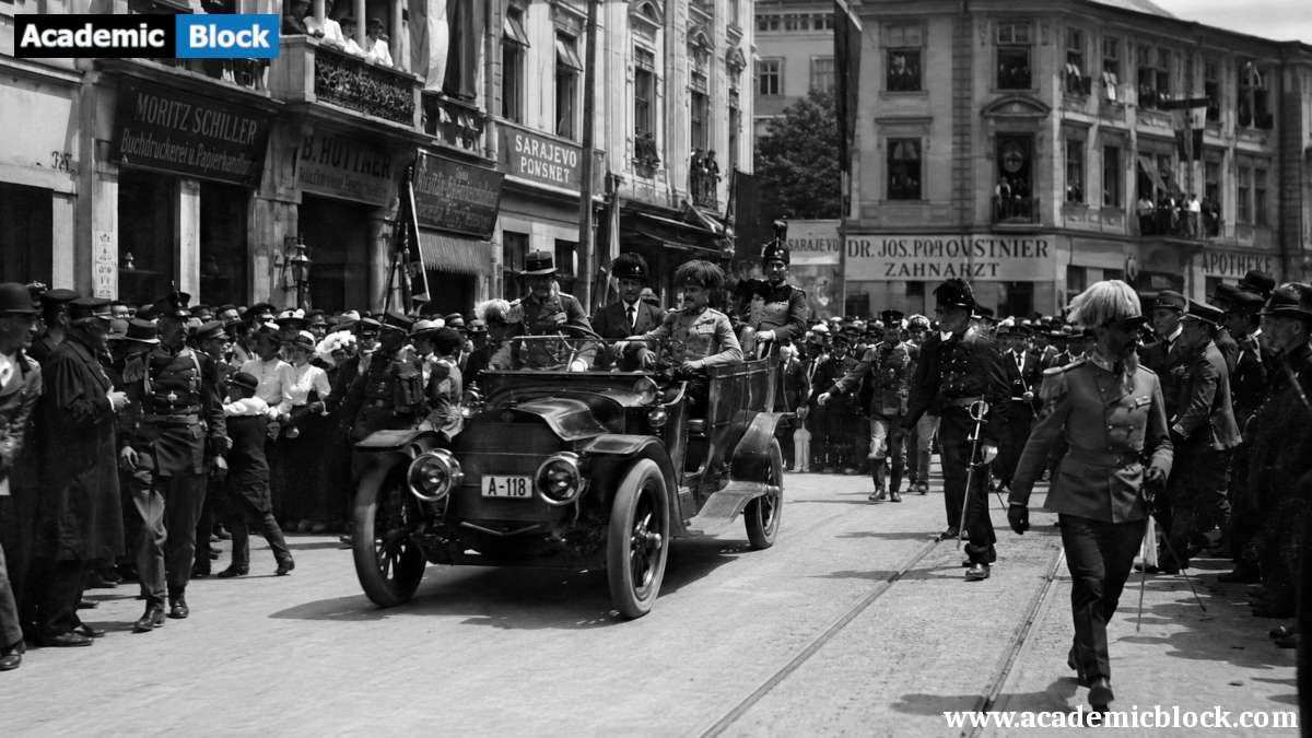 Image of of Archduke Franz Ferdinand's motorcade during the 1914 Sarajevo assassination, surrounded by crowds on a historic city street.