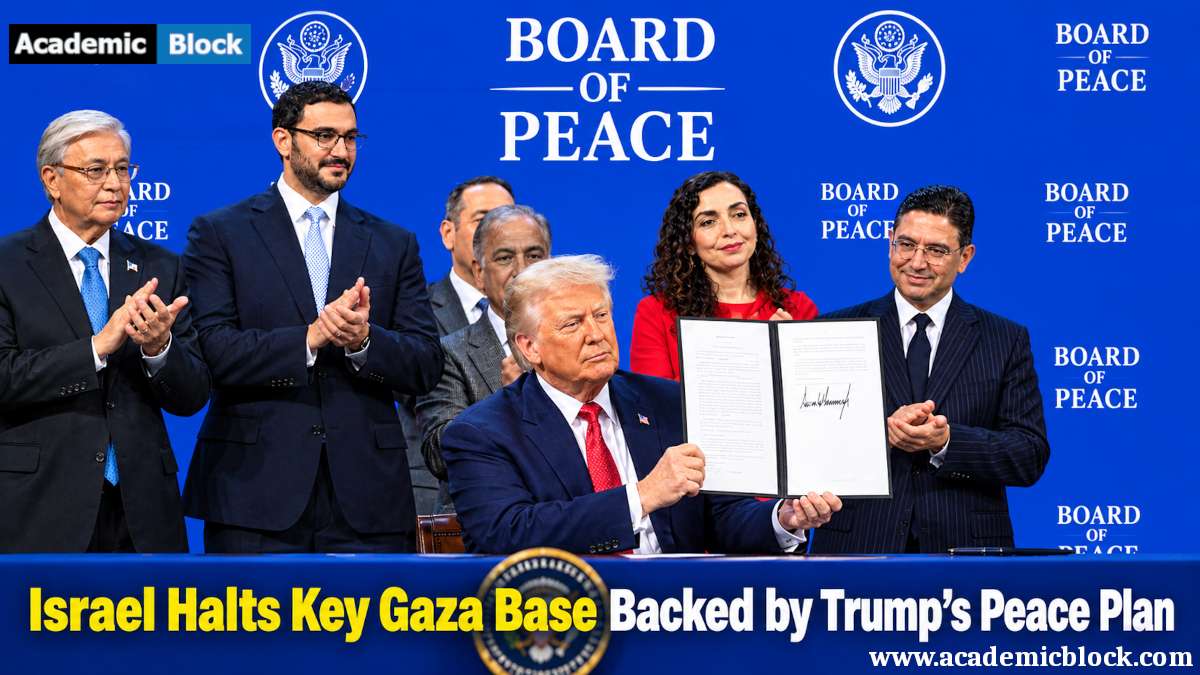 Image shows Donald Trump holds a signed document at a Board of Peace ceremony against a blue backdrop featuring, Board of Peace text, as officials applaud.